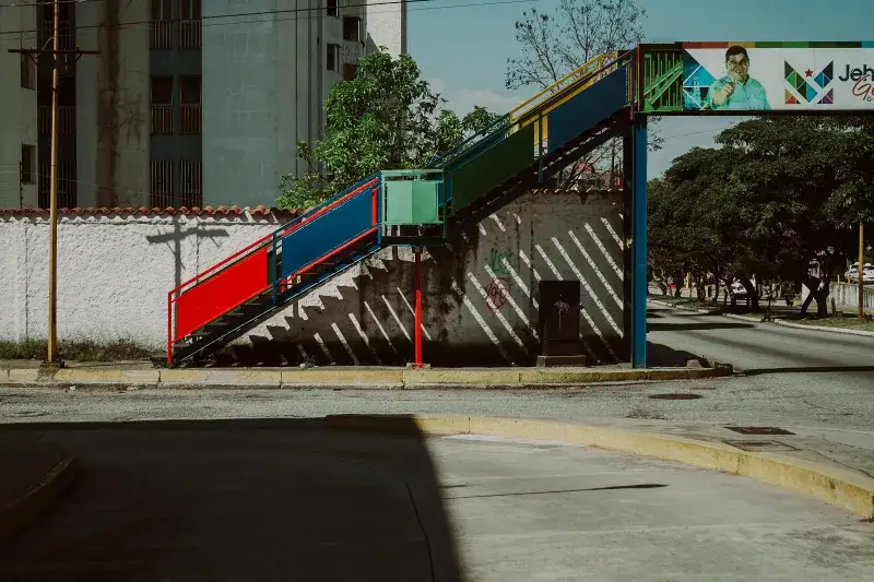 A vibrant pedestrian bridge over quiet urban streets in Mérida, Venezuela.