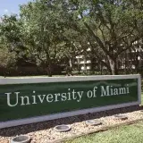 Outdoor view of the University of Miami entrance with lush greenery during the day.