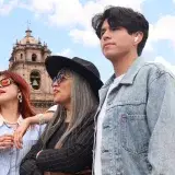 Group of friends visiting Cusco, Peru, in sunny weather, with historic architecture.