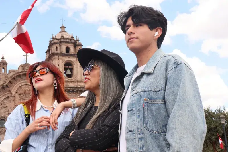 Group of friends visiting Cusco, Peru, in sunny weather, with historic architecture.