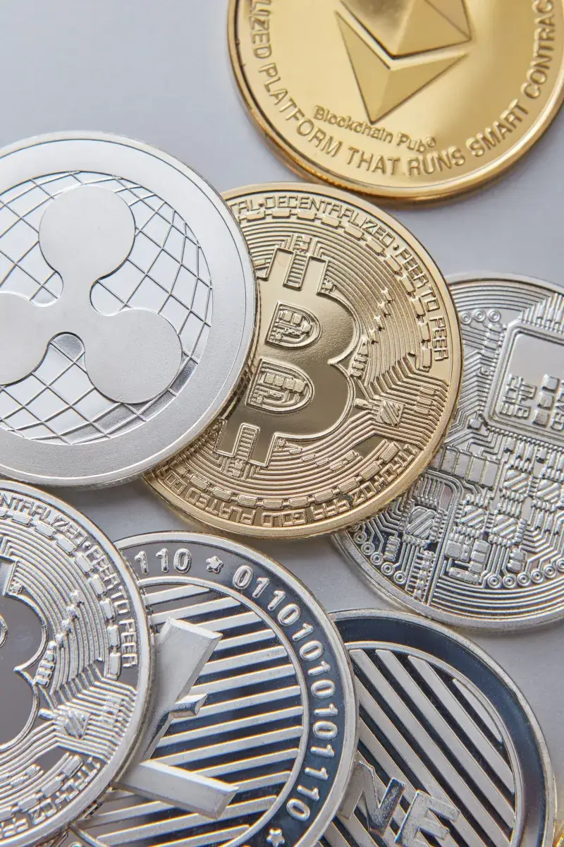 High-resolution vertical shot of various cryptocurrency coins, emphasizing Bitcoin, Ethereum, and Ripple.
