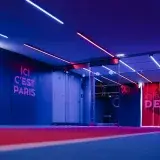 Pasillo de entrada amplio del PSG en París con iluminación neón llamativa y la marca del club.