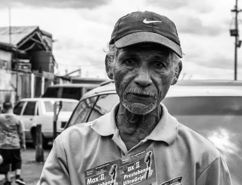 Black and white portrait of an elderly man selling products on the streets of Maracaibo, Venezuela.