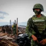 A soldier in camouflage uniform amidst a disaster site in Ciudad de Armería, Mexico.