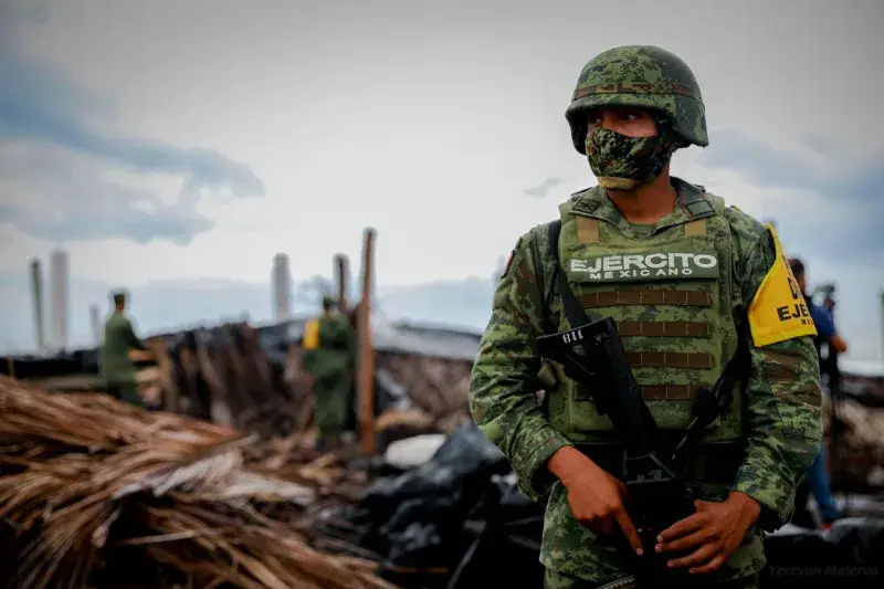 A soldier in camouflage uniform amidst a disaster site in Ciudad de Armería, Mexico.