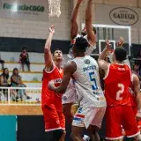 Exciting moment during a competitive basketball game, showcasing players striving for the ball near the basket.