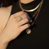 Close-up of elegant gold ring and necklaces worn by a woman. Perfect for fashion and jewelry stock photos.