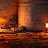 Rustic barrels with glowing embers emit warm light, showcasing raw energy and industrial ambiance.