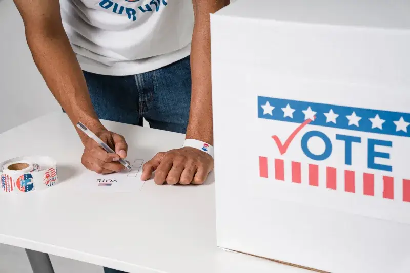 Close-up of man voting at ballot box, emphasizing democratic participation.