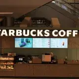 Interior view of a Starbucks Coffee shop with menu displays and counter setup.