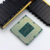 A CPU and RAM sticks displayed on a white surface, showcasing computer hardware components.