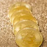 Close-up of gold bitcoins in a row, showcasing cryptocurrency's modern finance revolution.
