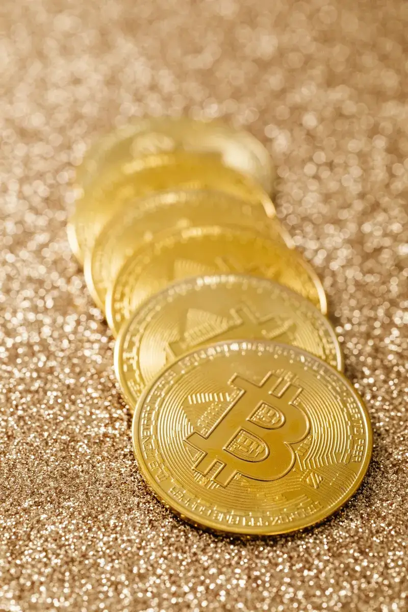 Close-up of gold bitcoins in a row, showcasing cryptocurrency's modern finance revolution.