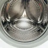 Detailed view of a clean, modern washing machine drum, showcasing shiny stainless steel interior.