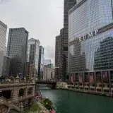 Scenic view of Chicago River with iconic skyscrapers and Trump Tower, capturing city life.