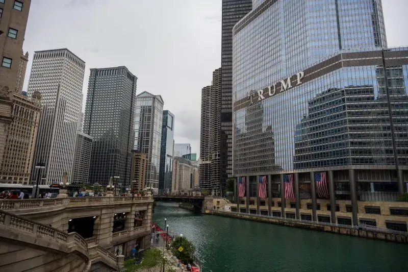 Scenic view of Chicago River with iconic skyscrapers and Trump Tower, capturing city life.