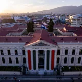 A captivating aerial shot of Palacio Nacional in San Salvador during sunset, showcasing vibrant city life and architecture.