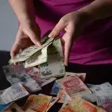 A person counts Argentine peso bills in Provincia de Buenos Aires, Argentina.