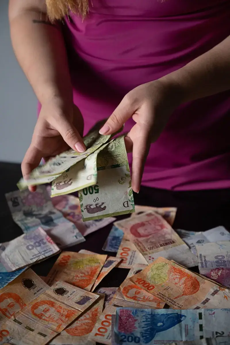 A person counts Argentine peso bills in Provincia de Buenos Aires, Argentina.
