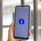 Close-up of smartphone with Facebook app open held by hand indoors.