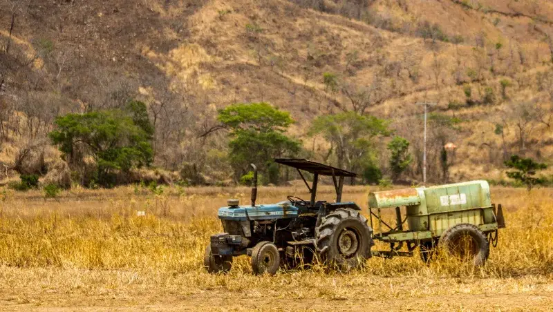 A tractor stands in a dry field in Cagua, Venezuela, capturing agricultural life.