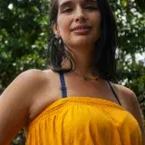 Smiling woman in yellow dress enjoying a sunny day outdoors in Mérida, Venezuela.