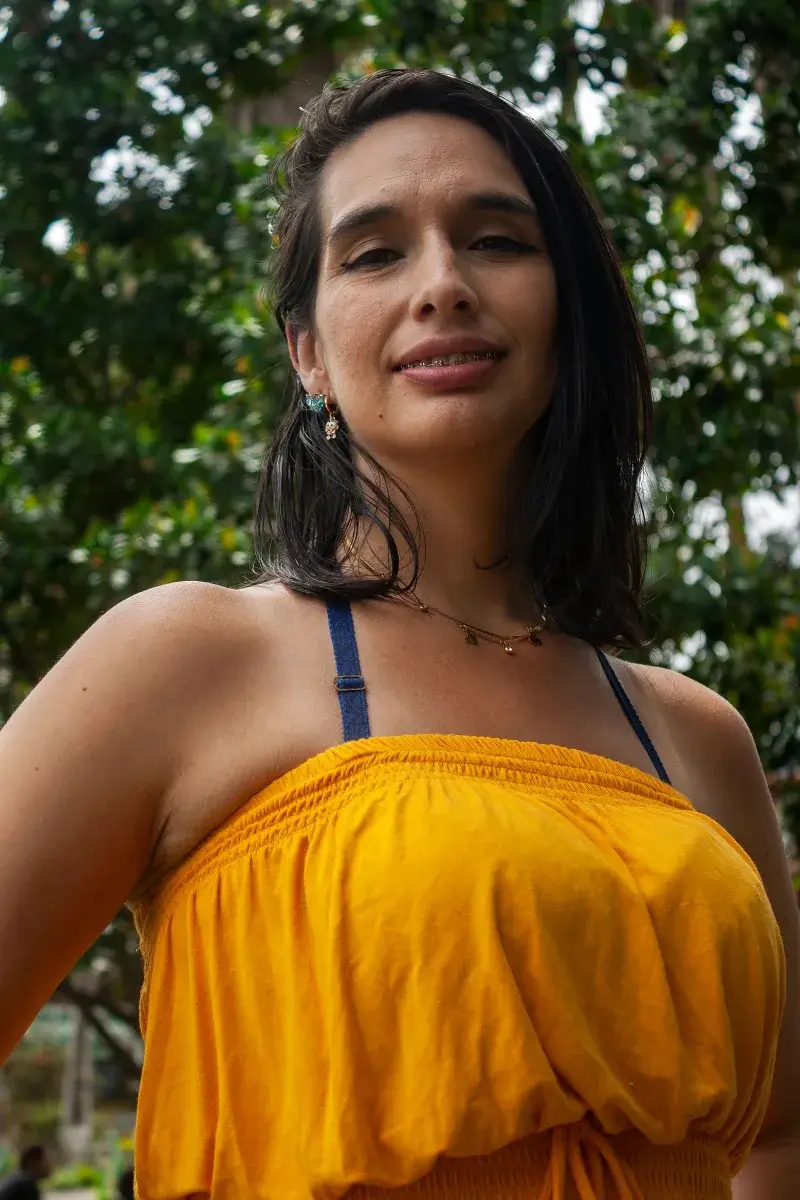 Smiling woman in yellow dress enjoying a sunny day outdoors in Mérida, Venezuela.