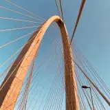 Stunning arch of a suspension bridge in São José dos Campos, Brazil, against a clear blue sky.