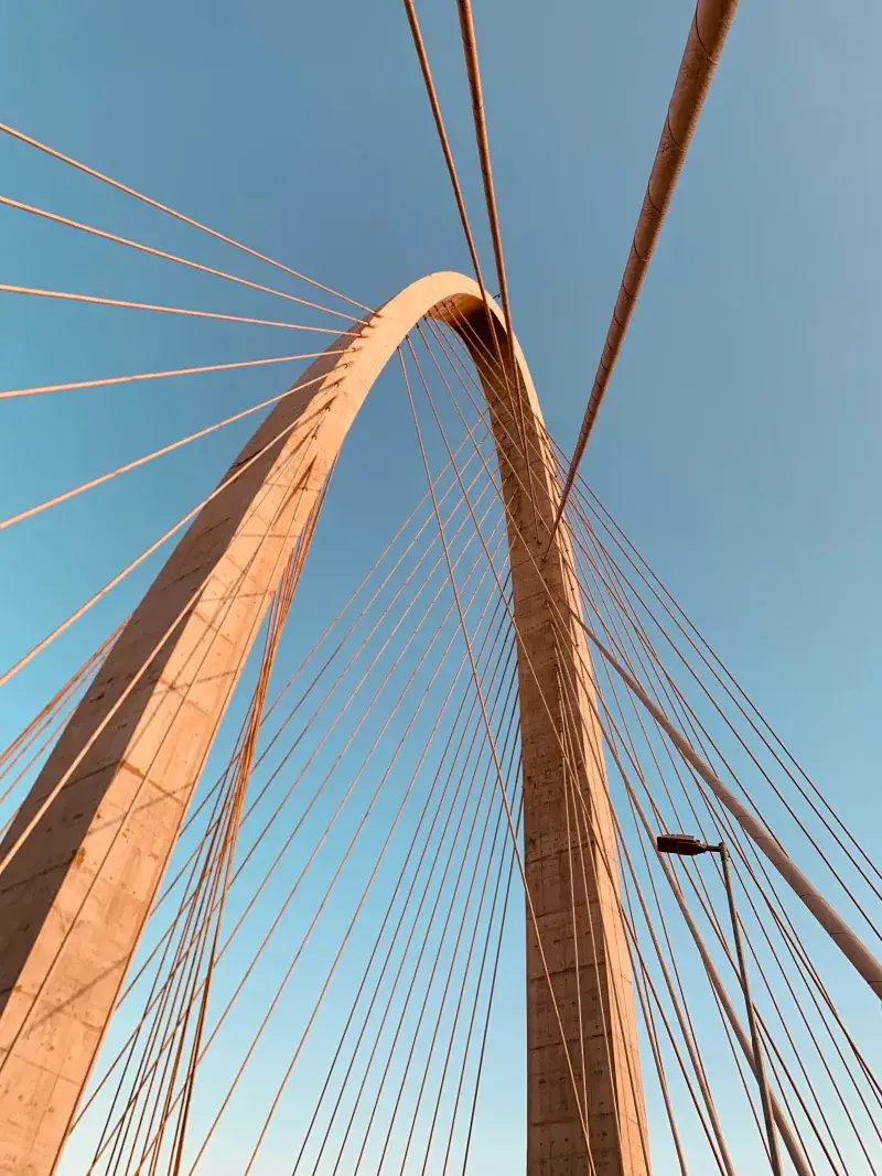 Stunning arch of a suspension bridge in São José dos Campos, Brazil, against a clear blue sky.