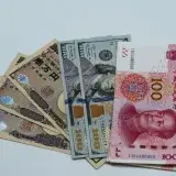 Various international currency notes including US dollars, yen, and yuan arranged on a surface.