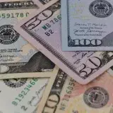 Detailed view of US currency, including $50 and $100 bills, symbolizing finance and economy.