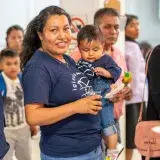 Smiling adults and children gather at a lively community event in Mexico City, CDMX.