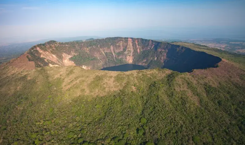 Stunning aerial view of a volcanic caldera surrounded by lush greenery in Nicaragua.