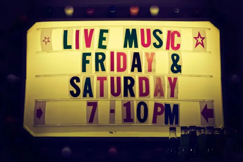 Illuminated vintage marquee promoting live music nights on Friday and Saturday.