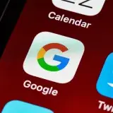 Macro view of a smartphone displaying Google and other app icons on the home screen.