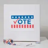 Ballot box with vote sign surrounded by voting stickers, indicating election theme.