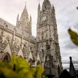 Stunning view of the iconic Gothic Basilica del Voto Nacional in Quito, Ecuador with cloudy sky.