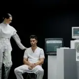 A modern scene with people in futuristic fashion amidst vintage technology.