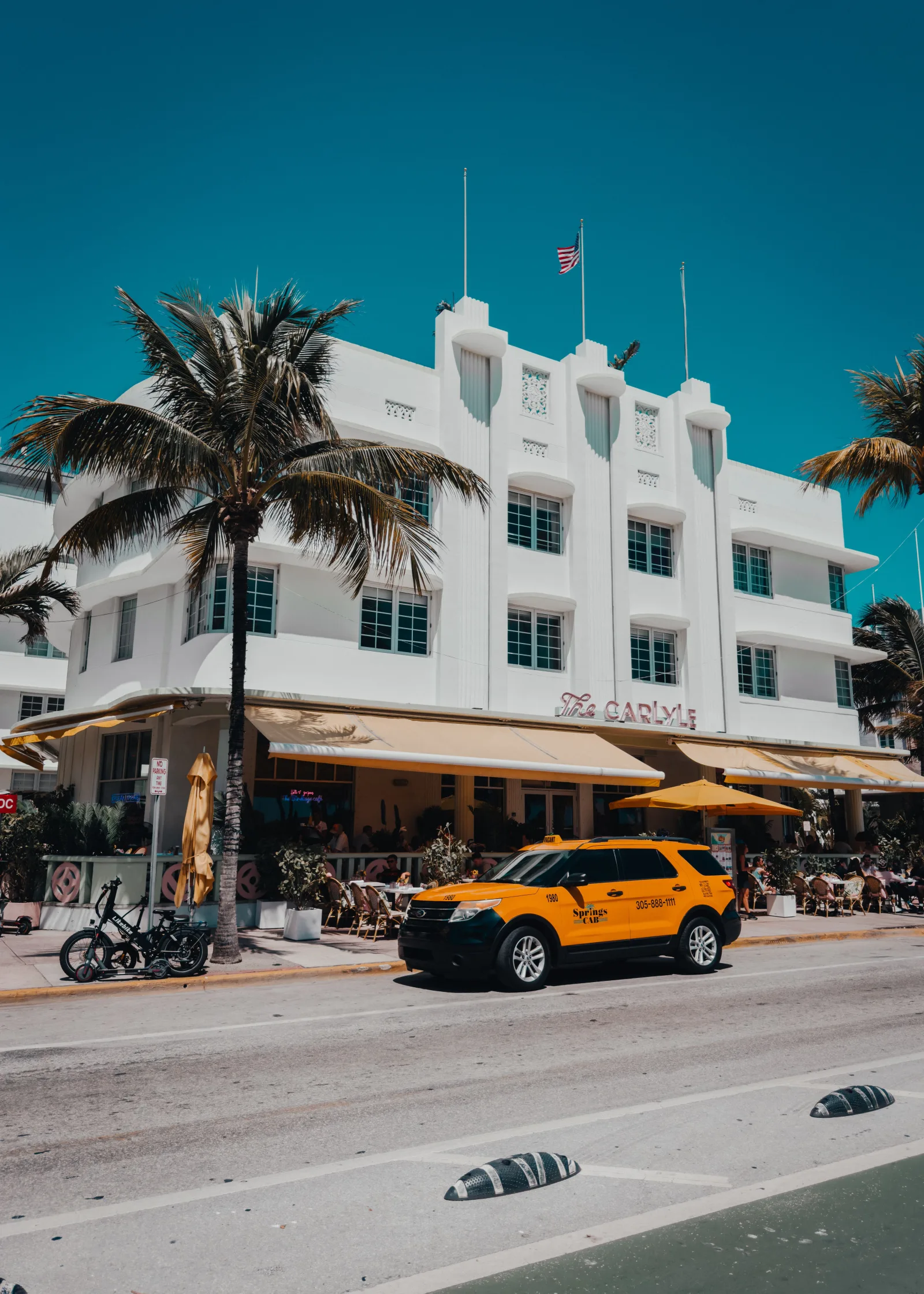 Bright day on Ocean Drive featuring the iconic Art Deco style Carlyle building in Miami Beach, Florida.