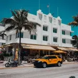 Bright day on Ocean Drive featuring the iconic Art Deco style Carlyle building in Miami Beach, Florida.