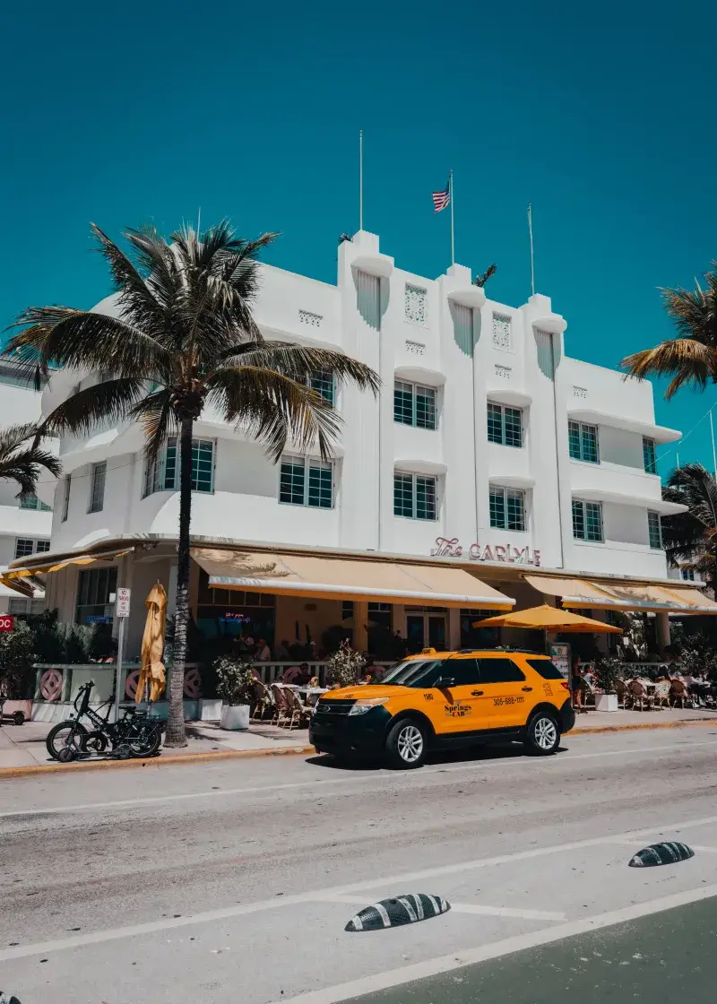 Bright day on Ocean Drive featuring the iconic Art Deco style Carlyle building in Miami Beach, Florida.