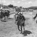 Traditional Mexican charros riding horses in a rural rodeo arena, San Juan Tizahuapan.