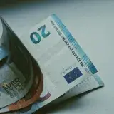 Detailed close-up of Euro banknotes on a white surface, focusing on currency design.