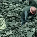 A woman mining for gold in La Rinconada, Peru, surrounded by rocks and debris.