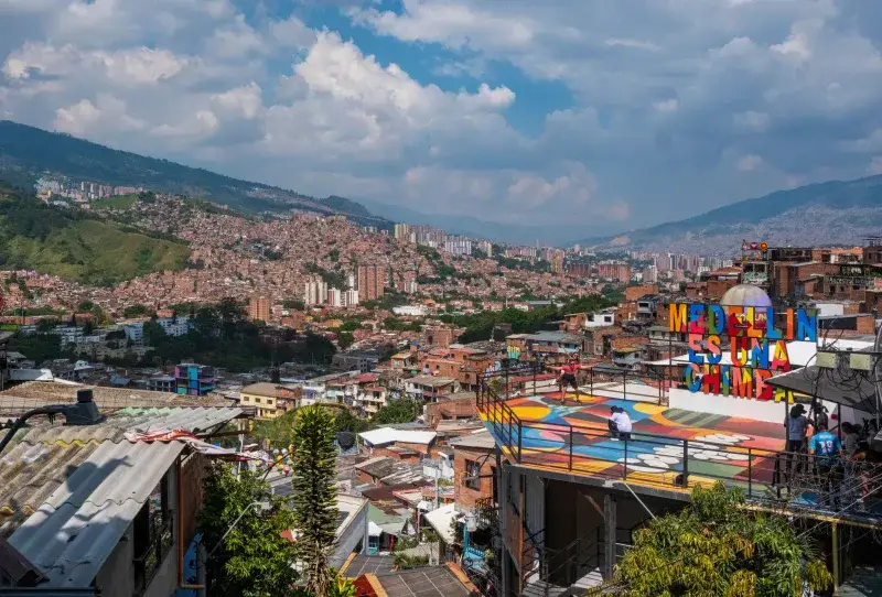 Panoramic view of Medellín's vibrant cityscape and mountains under a clear sky.