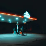 A neon-lit Petro Canada gas station illuminated against the night sky.