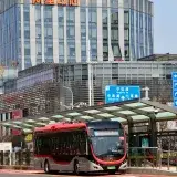 Electric bus in front of Alibaba building, capturing modern urban transit in Shanghai.