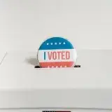 Close-up of an I Voted badge on a ballot box, symbolizing voting in the USA elections.