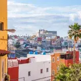 Vibrant street view of Las Palmas de Gran Canaria, showcasing colorful buildings and urban charm.