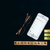 Smartphone displaying cryptocurrency market status with blockchain concept on black backdrop.